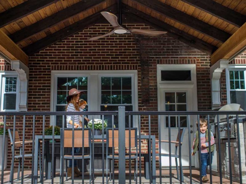 Covered Deck Wood Ceiling Black Railing Brick House