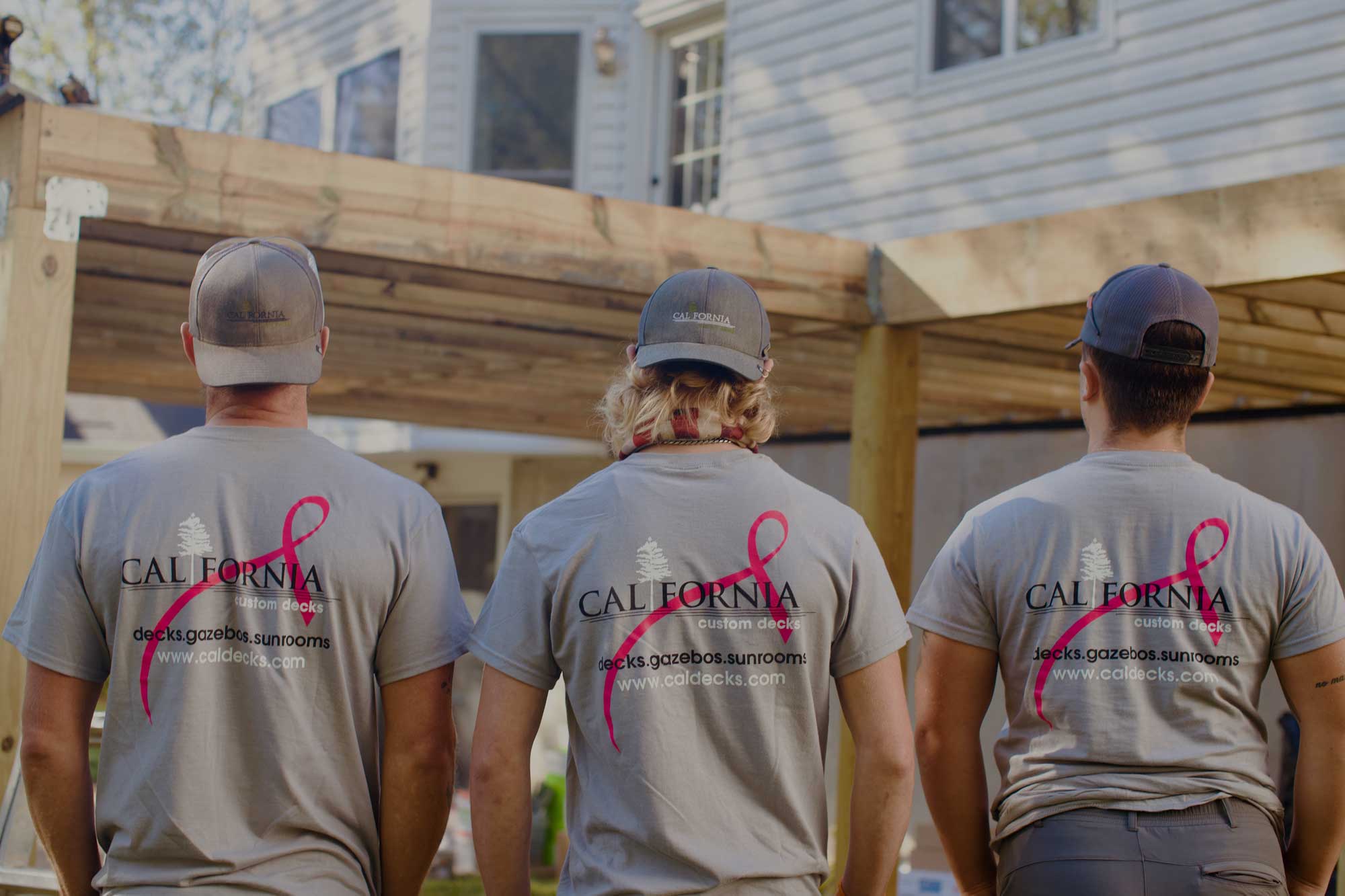 Deck builders wearing breast cancer awareness shirts in St. Louis, MO