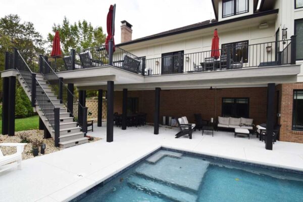 Under deck patio and open composite wood deck and stairs by pool in Ladue, MO