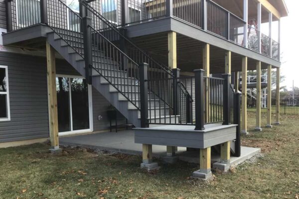 Grey covered deck with black railing in Manchester, MO