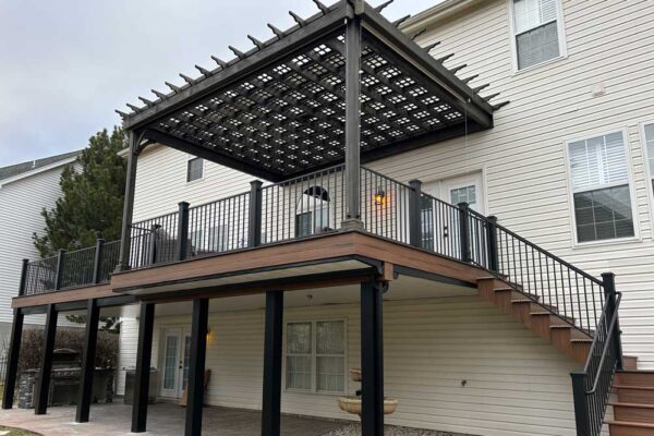 New custom composite wood deck with black railings and dark wood pergola in St. Charles County, MO