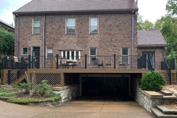 Open deck and deck stairs with black railing and garage underneath in St. Louis City, MO